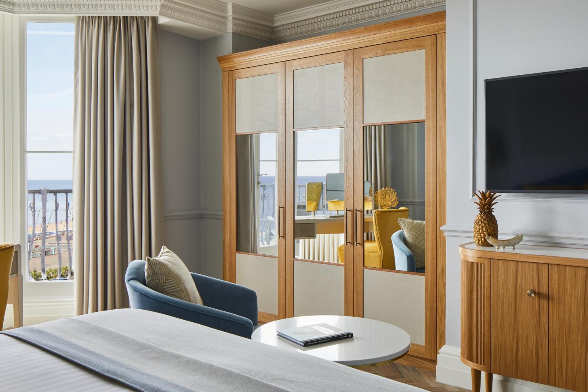 The Grand Brighton Hotell Exteriör bild The photo depicts a modern hotel room or a stylish living space. Key features include:

- A wooden wardrobe with mirrored doors, providing a touch of elegance and functionality.
- A comfortable blue armchair positioned near the wardrobe.
- A round co