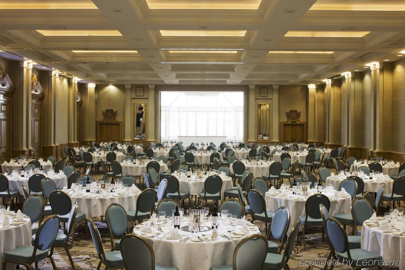 The Grand Brighton Hotell Exteriör bild The photo depicts a large banquet hall set up for dining. The space features several round tables, each covered with white tablecloths and adorned with plates, glasses, and cutlery, indicating a formal arrangement for a meal or event. The chairs surr